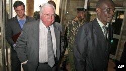 FILE - Jerome Corsi, center, who wrote "The Obama Nation: Leftist Politics and the Cult of Personality," follows an immigration department officer holding his passport in Nairobi, Kenya, Oct. 7, 2008.