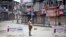 An Indian policeman stands guard at a temporary checkpoint during a curfew in Srinagar, India, March 14, 2013.