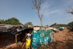 FILE - A girl carries a baby on her back at the Kuchingoro internally displaced persons camp, in Abuja, Nigeria, June 20, 2020.