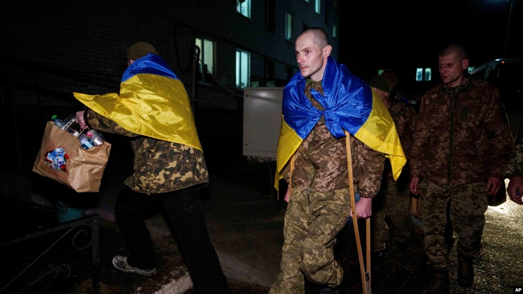 Украинскиот војник Јевхен Лиашенко користи штаки додека се упатува кон својата сопруга по враќањето од руско заробеништво, за време на размена на воени заробеници на неидентификувана локација во Украина, 30 декември 2024 година.