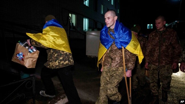 Український військовий Євген Ляшенко на милицях приїжджає зустрітися з дружиною після повернення з російського полону під час обміну військовополоненими в невстановленому місці в Україні, 30 грудня 2024 року.