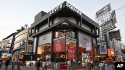 People walk past an American apparel brand store in Bangalore, India, January 11, 2012.