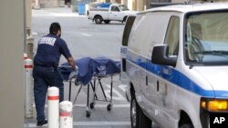 A person from the Los Angeles County Department of Medical Examiner-Coroner's office removes a body at the scene of a fatal shooting at the University of California, Los Angeles, June 1, 2016, in Los Angeles.