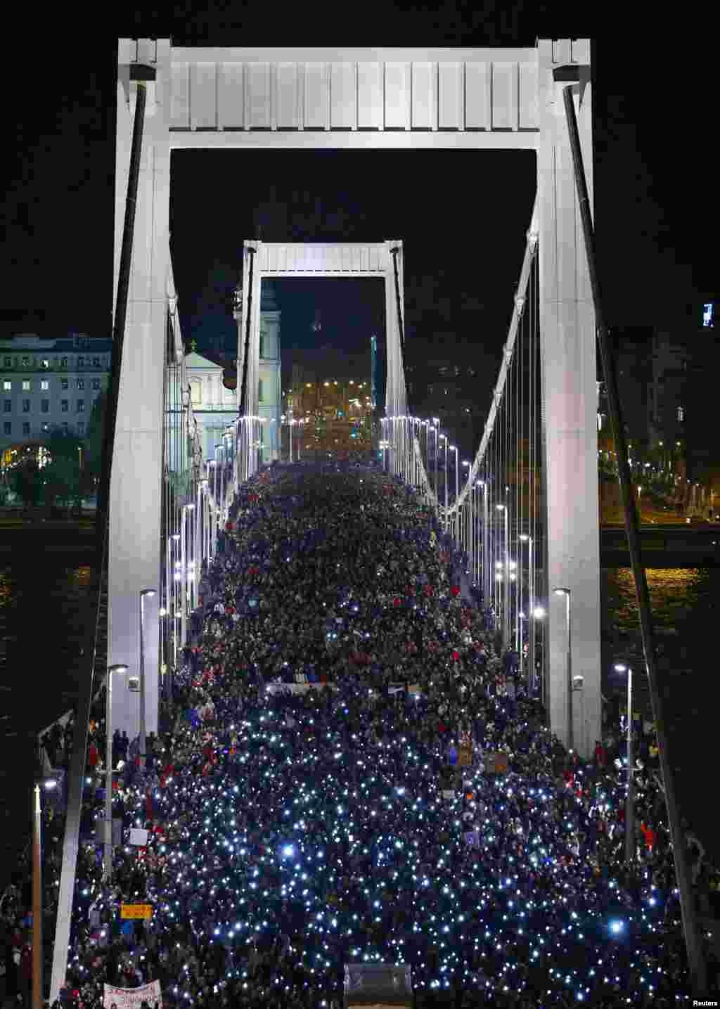 Tens of thousands of Hungarians march across the Elisabeth Bridge during a protest against new tax on Internet data transfers in centre of Budapest, Oct. 28, 2014. 