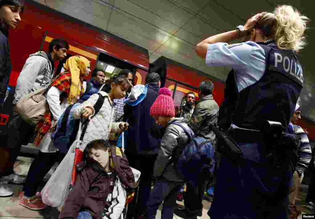 A German border police woman at the railway station of the airport in Frankfurt&nbsp;reacts after dozens of migrants unexpectedly disembarked a train that departed from Budapest&#39;s Keleti station.