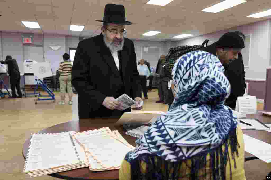 Seorang warga mengukuhkan alamatnya kepada petugas di TPS Boro Park, Brooklyn, New York. Daerah ini memiliki populasi besar warga Yahudi dan Muslim. (AP/Mark Lennihan)