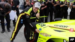 Simon Pagenaud of France places the pole award on his car during following qualifications for the Indianapolis 500 IndyCar auto race at Indianapolis Motor Speedway, in Indianapolis, May 19, 2019.
