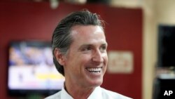FILE - In this May 31, 2018 file photo Democratic Lt. Gov. Gavin Newsom smiles at a campaign stop at Stakely's Barber Salon in Los Angeles. 