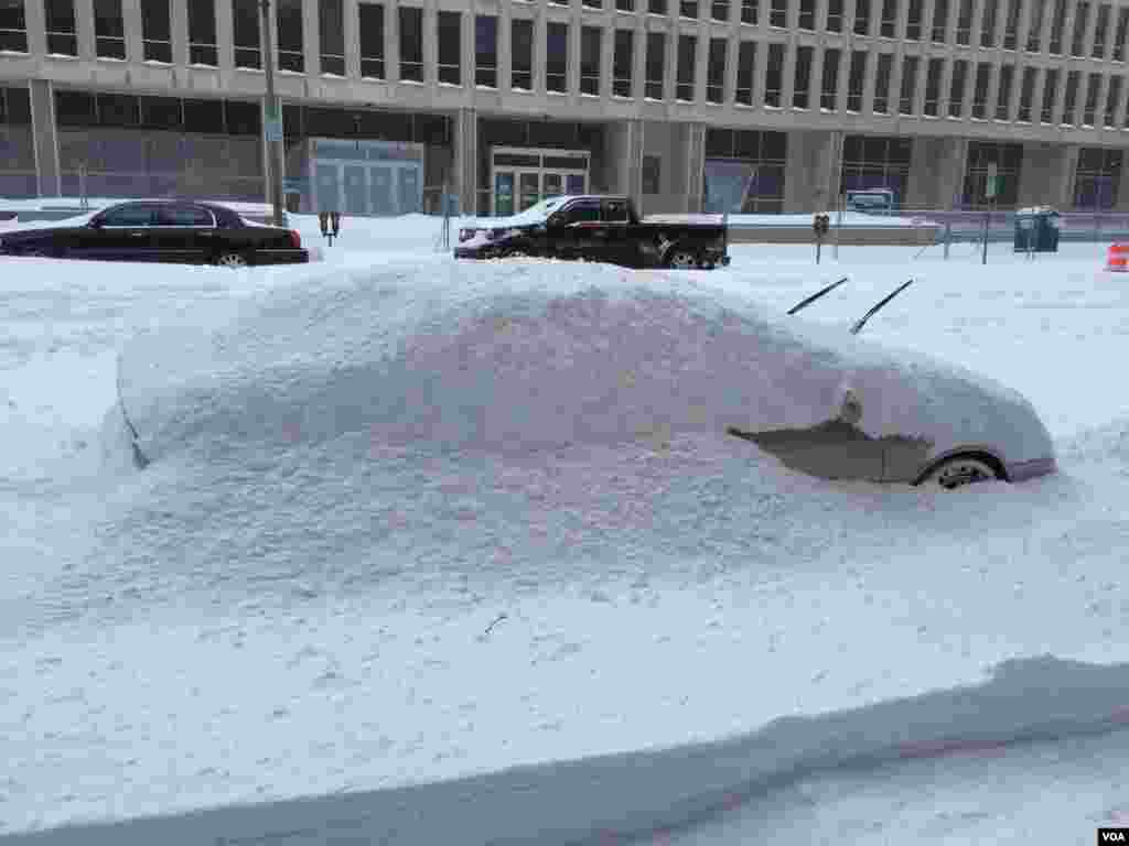 A vehicle is covered by snow as it continue to fall in Washington DC, Saturday 23 Jan, 2016 (VOA PHOTO Abdulaziz Osman)