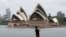 FILE - A man films the harbor foreshore on his mobile phone ahead of New Years Eve in Sydney, Australia, Dec. 31, 2020. 