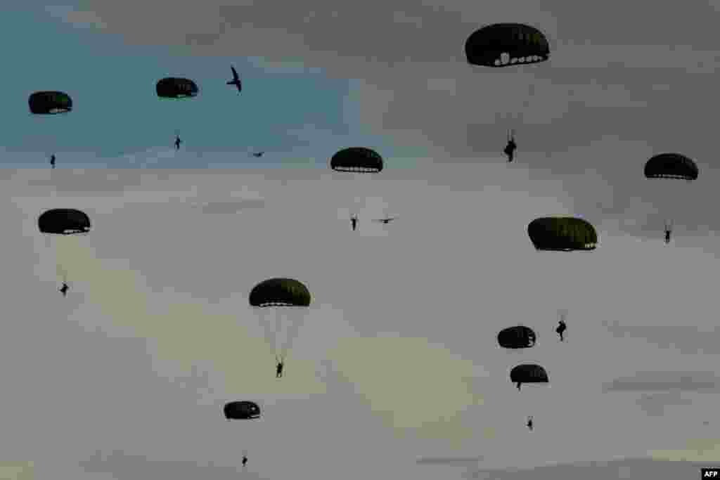 Indonesian paratroopers descend with their chutes during the Jalak Sakti military exercise held at the Sultan Iskandar Muda Air Force Base in Blang Bintang, Aceh province.