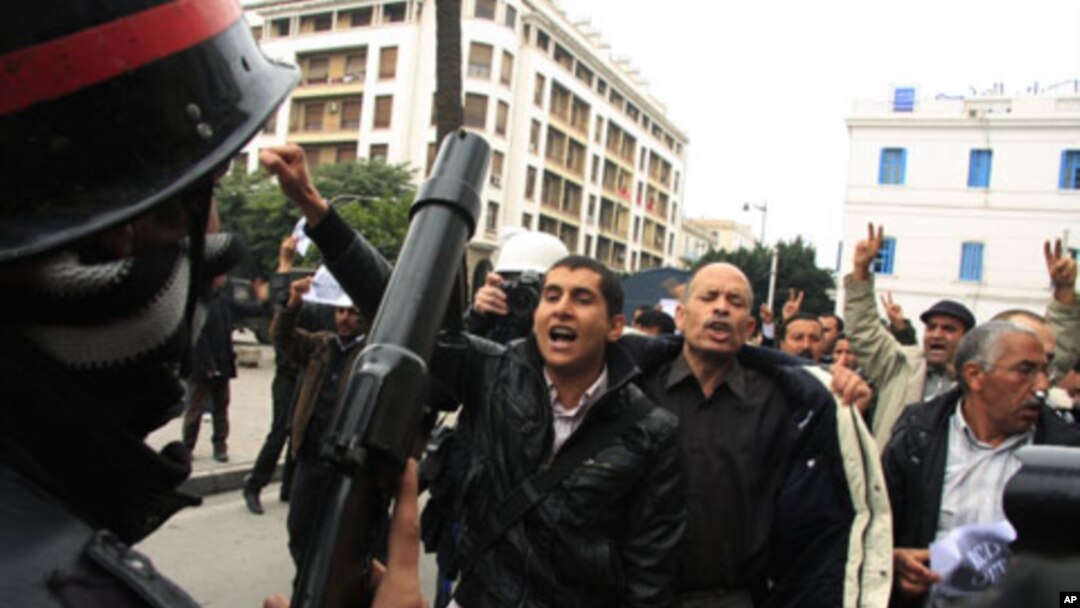 A riot policeman faces off with protesters during a demonstration in downtown Tunis, Tunisia, 18 Jan 2011