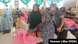 Produksi baju khusus untuk alat perlindungan diri di ruang jahit dan sablon di SMK Negeri 5 Palu, 31 Maret 2020. (Foto: VOA/Yoanes Litha)