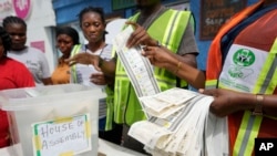 FILE - Electoral officials count ballots in front of party agents and observers at a polling station in Lagos, Nigeria, Saturday, March 18, 2023