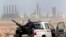 Libya Oil: FILE - In this March 5, 2011 file photo, an anti-government rebel sits with an anti-aircraft weapon in front an oil refinery in Ras Lanouf, eastern Libya. 