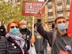 Protester Frikia, left, offered a raft of complaints against the government, during the International Workers' Day march in Paris, May 1, 2021. (Lisa Bryant/VOA)