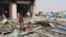 A man stands at the scene of an airstrike that hit a truck at a gas station in Abss, Yemen, April 24, 2018. 