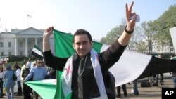 A protest leader unfurls a Syrian flag in front of the White House Saturday, seeking more U.S. action to protect civilians in Syria.