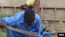 Dosso Abou clears brush to support himself, his wife and their five children, Bouake, Ivory Coast, May 4, 2013. (R. Corey-Boulet/VOA)