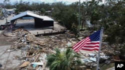 An American flag flies over the destroyed city hall in the aftermath of Hurricane Helene, in Horseshoe Beach, Florida, Sept. 28, 2024. 