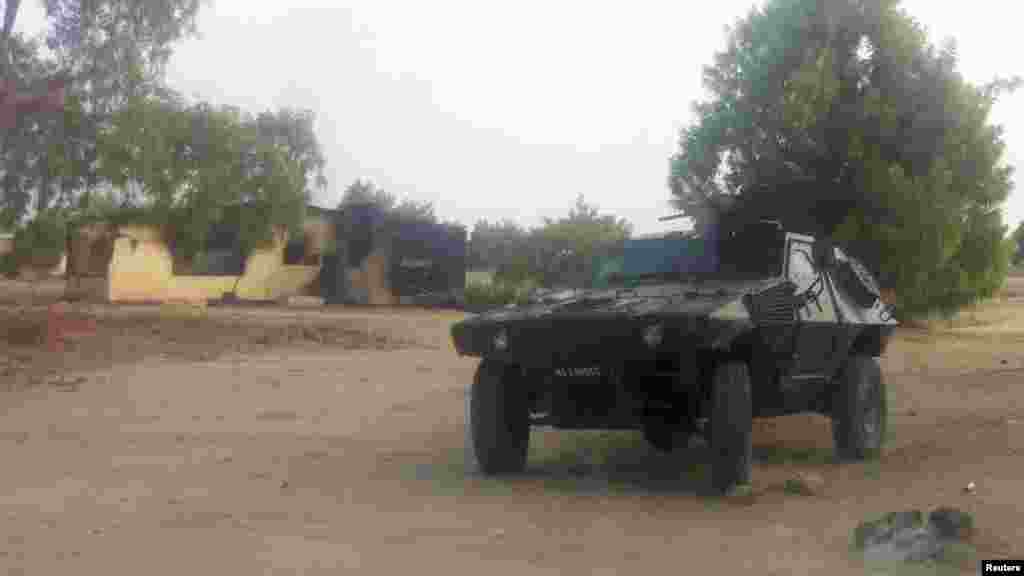 A military vehicle is seen in front of a burnt house in Bama, Maiduguri, Borno State, Nigeria. May 7, 2013.