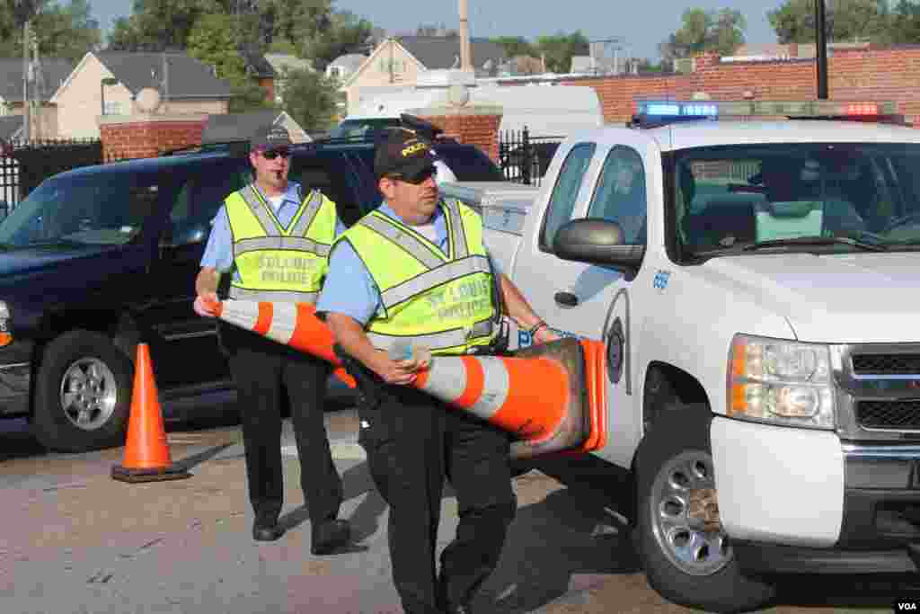 La policia local de St. Louis, Missouri, tratando de establecer ciertos límites o barricadas en los alrededores de la iglesia. [Foto: Alberto Pimienta, VOA]