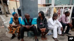 Staff members of This Day newspaper sit outside, as workers barricaded the front office due to non payment of salaries in Lagos, May 10, 2013.