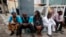 Staff members of This Day newspaper sit outside, as workers barricaded the front office due to non payment of salaries in Lagos, May 10, 2013.