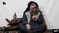 FILE - The chief of the Islamic State group, Abu Bakr al-Baghdadi, purportedly appears for the first time in five years in a propaganda video in an undisclosed location, in this undated TV grab taken from video released April 29 by Al-Furqan media.