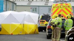 Fire officers stand inside a cordon at the vehicle recovery business "Ashley Wood Recovery" in Salisbury, England, March 13, 2018. 