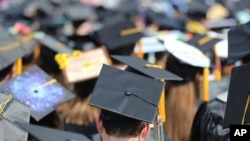 FILE - In this May 5, 2018, file photo, graduates at the University of Toledo commencement ceremony in Toledo, Ohio. Colleges across the U.S. have begun cancelling and curtailing spring graduation events amid fears from the coronavirus. 