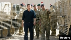 Britain's Prime Minister David Cameron (L) is given a tour of some of the heavy equipment used in operations, during his visit to Camp Bastion in Helmand province, Afghanistan June 29, 2013. Cameron flew into Afghanistan on Saturday to try to reinvigorate