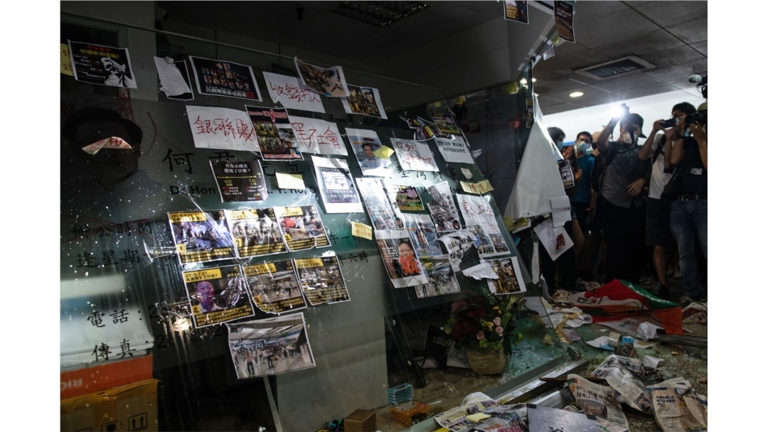 The smashed glass entrance to the office of pro-Beijing government lawmaker Junius Ho is seen as protesters gather in Hong Kong's Tsuen Wan district on July 22, 2019.