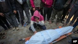 A man mourns over the body of a Palestinian man killed during an Israeli army strike in Deir al-Balah in the central Gaza Strip, Jan. 2, 2025. 