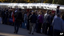 Demonstrators march with a replica of a pipeline during a protest to demand a stop to the Keystone XL tar sands oil pipeline outside the White House on Sunday, Nov. 6, 2011, in Washington.