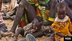 Los refugiados esperan ayuda junto a sus niños el campo de Kakuma en el districto de Turkana, al noreste de Nairobi, la capital de Kenia.