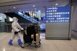 A Chinese woman wearing a protective gear waits for her flight at the Incheon Airport in Incheon, South Korea, March 19, 2020. South Korea reported an uptick in coronavirus cases after four days of falling numbers.