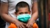 A child wearing face mask waits for COVID-19 test outside a government apartment in Kampung Baru, a traditional Malay village in Kuala Lumpur, Malaysia, Wednesday, April 15, 2020. The Malaysian government issued a restricted movement order to the…