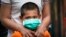 A child wearing face mask waits for COVID-19 test outside a government apartment in Kampung Baru, a traditional Malay village in Kuala Lumpur, Malaysia, Wednesday, April 15, 2020. The Malaysian government issued a restricted movement order to the…