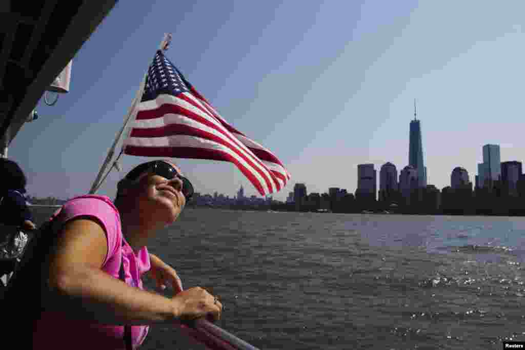 A woman rides a ferry on the harbor in New York City.