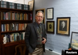 FILE — Carel Boshoff, son of the founder of Orania Carel Boshoff, and grandson of apartheid architect Hendrik Verwoerd, poses in front of a portrait of his grandfather at his office, in the tiny whites-only town of Orania, May 28, 2024.