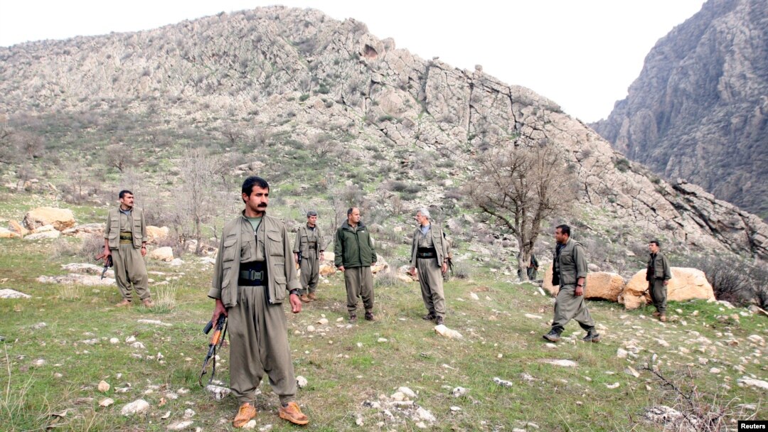 PKK fighters stand guard during the release of eight Turkish prisoners in the northern Iraqi city of Dohuk, March 13, 2013. (Reuters)