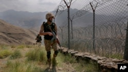 FILE - In this Aug. 3, 2021 file photo, Pakistan Army troops patrol along the fence on the Pakistan Afghanistan border at Big Ben hilltop post in Khyber district, Pakistan.