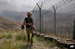 FILE - Pakistani army troops patrol along the border with Afghanistan at Big Ben post in Khyber district, Pakistan, on Aug. 3, 2021.