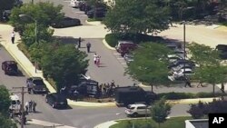 In this frame from video, people leave The Capital newspaper building after multiple people were shot, June 28, 2018, in Annapolis, Md. 