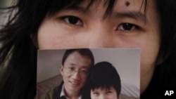 Zeng Jinyan, the wife of jailed Chinese dissident and AIDS activist Hu Jia, holds a photo of the couple and their baby, during an interview in Beijing, December 1, 2010. (file photo)