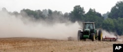 FILE - In this May 31, 2007, file photo, a farm tractor stirs up dust as it moves across a field on a farm along state road 82 near Tifton, Georgia.