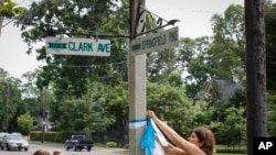 FILE - Denise Koesterman, right, and Alison Lebrun, left, tie blue-and-white awareness ribbons along Springfield Pike near the family home of Otto Warmbier, a 22-year-old University of Virginia undergraduate student who was imprisoned in North Korea.