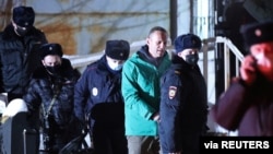 Russian opposition leader Alexei Navalny is escorted by police officers after a court hearing, in Khimki outside Moscow, Russia Jan. 18, 2021. (Evgeny Feldman/Meduza/Handout)