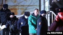 FILE - Alexei Navalny is escorted by police officers after a court hearing, in Khimki outside Moscow, Russia Jan. 18, 2021. The Kremlin critic remains jailed. (Evgeny Feldman/Meduza/Handout)